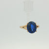 14K yellow gold ring featuring a 10 x 9mm oval deep blue sapphire in a four-prong setting.