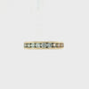 A yellow gold eternity ring featuring a row of round brilliant-cut diamonds set in a polished band, shown against a plain white background.