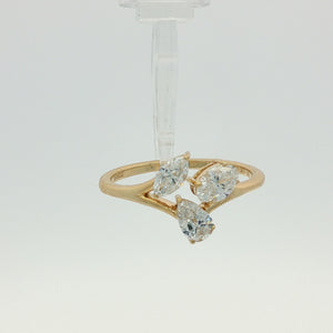 A yellow gold ring featuring three marquise-cut diamonds on a split shank, photographed on a clean white background.