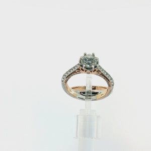 A diamond engagement ring and matching diamond wedding band shown on a white background. The ring features a round-cut diamond center stone in a prong setting with a rose gold and white gold band accented by pavé diamonds.