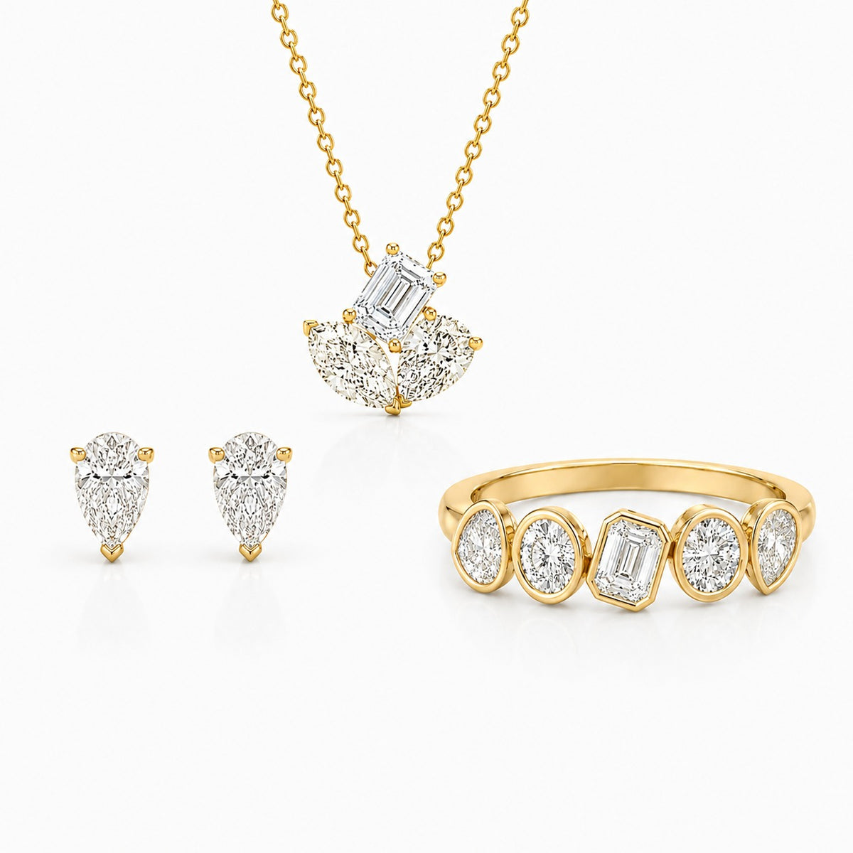 Elegant yellow gold jewelry set featuring pear and emerald-cut diamonds, including stud earrings, a pendant necklace, and a modern multi-stone ring on a light gray background.