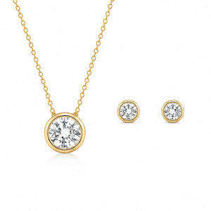 Gold necklace and earrings with clear gemstones on a white background