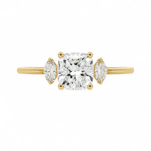 A yellow gold three-stone engagement ring featuring a large cushion-cut center diamond flanked by two marquise-cut side diamonds, set against a plain white background.